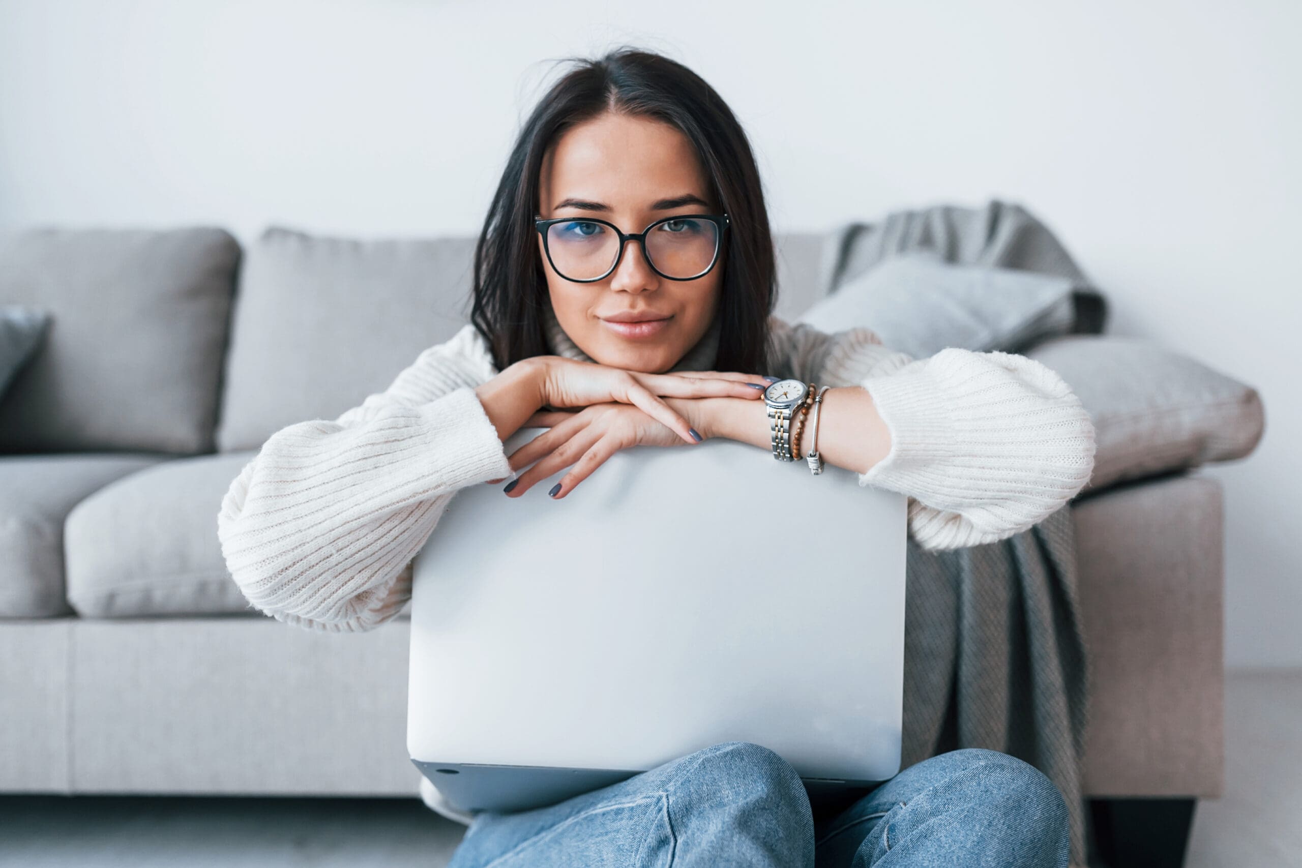 Young Beautiful Woman In Glasses Sitting At Home Alone With Lapt